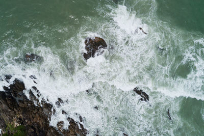 High angle view of waves splashing on rocks