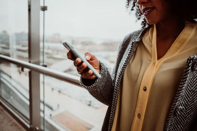 Midsection of woman using mobile phone