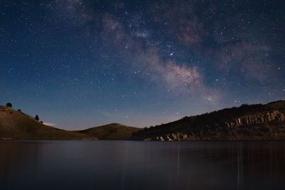 Scenic view of lake against mountains at night