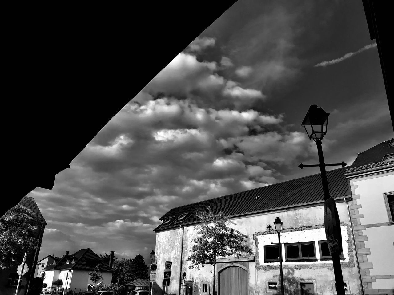 LOW ANGLE VIEW OF STREET LIGHT BY BUILDINGS AGAINST SKY