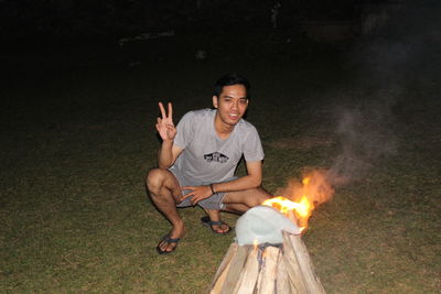 Portrait of smiling young man sitting on fire