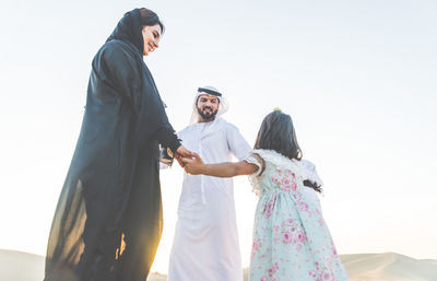 Happy family playing on sand dune