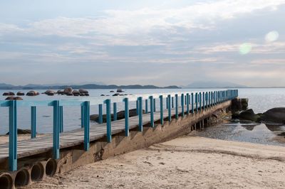 Wooden posts on beach against sky