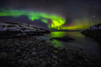 Scenic view of snow covered rocks against sky at night