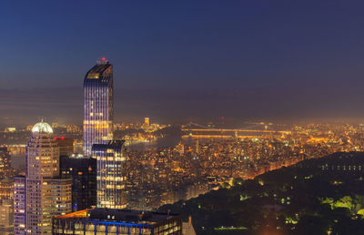 Illuminated cityscape against sky at night