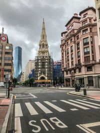 View of city street and buildings against sky