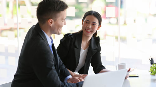 Portrait of smiling businesswoman using laptop at office