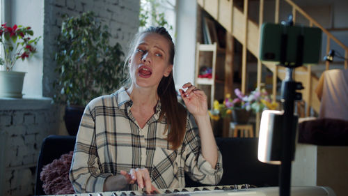 Mother singing while playing piano at home