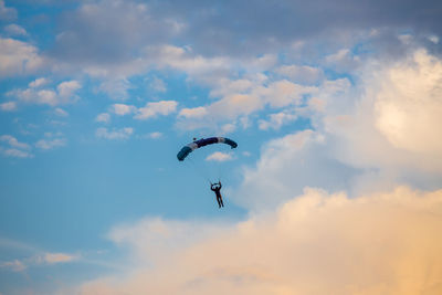 Low angle view of people flying in sky