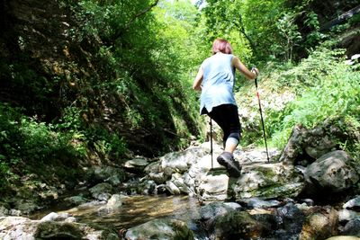 Full length of man standing by rocks in forest