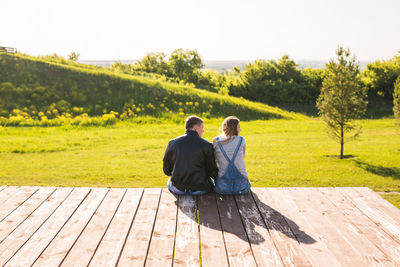 Rear view of couple sitting on landscape