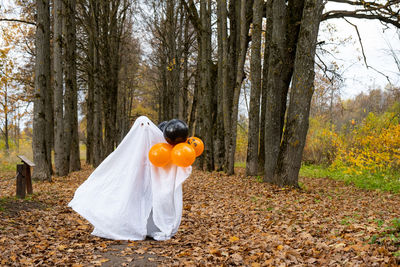 Rear view of woman standing in forest