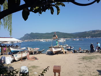 Boats moored in sea against clear sky