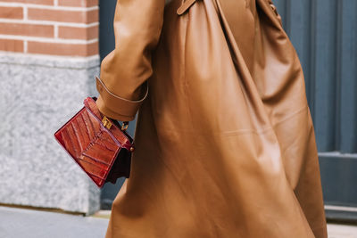 Midsection of woman standing against wall