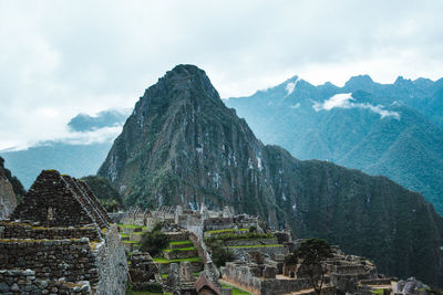 Old ruins of machu picchu against mountains during foggy weather