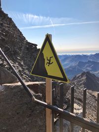 Information sign on road against sky