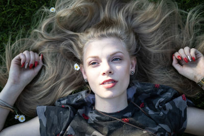 High angle view of young woman lying on grassy field