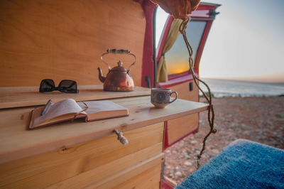 Book and cup in motor home at beach