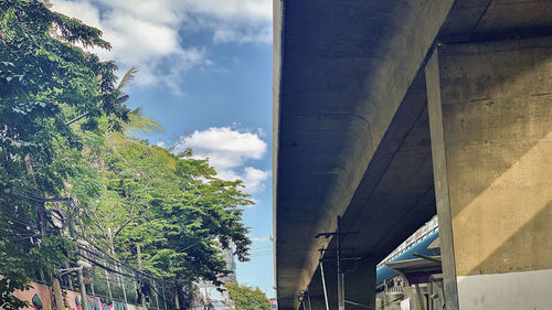 Low angle view of trees and buildings against sky