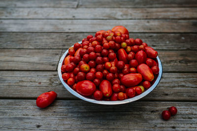 Bowl of tomatoes on wood