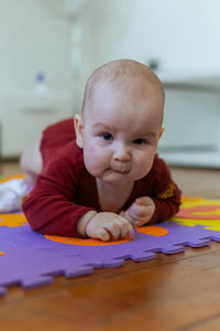 Cute baby crawling on the floor looking to the camera