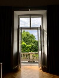 Trees seen through open window of house