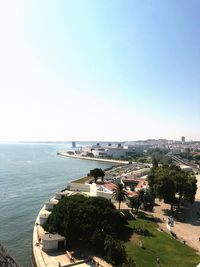 High angle view of buildings by sea against clear sky