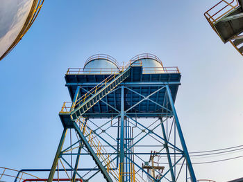 Low angle view of ferris wheel against clear blue sky