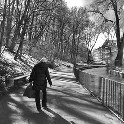 Rear view of people walking on footpath
