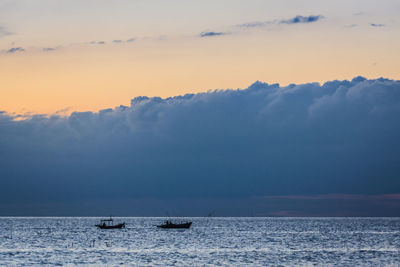 Boats in sea during sunset