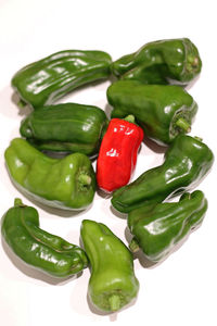 Close-up of green chili peppers on white background