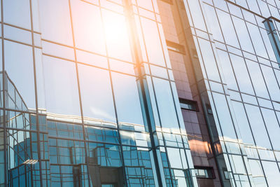 Low angle view of glass building against sky