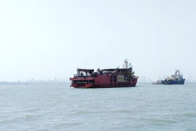 Ship sailing on sea against clear sky