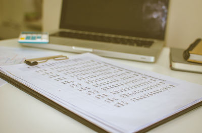 Close-up of business report by laptop on desk