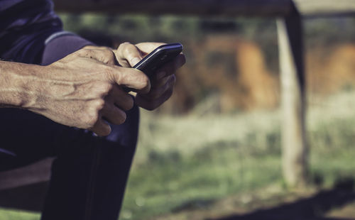 Close-up of man using mobile phone outdoors