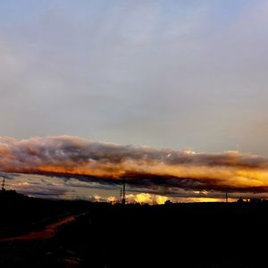 Smoke emitting from factory against sky during sunset