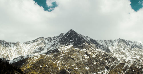 Low angle view of snowcapped mountains against sky