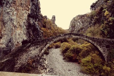 Bridge over mountain against clear sky