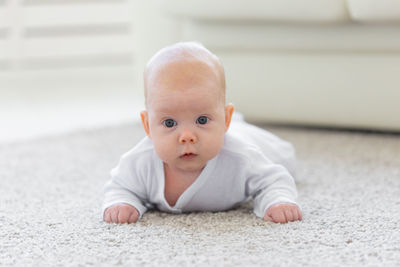 Portrait of cute baby boy on floor