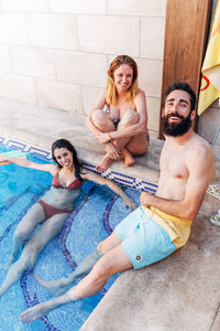 Young couple sitting on swimming pool