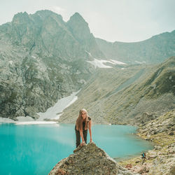 Woman standing on rock against mountains