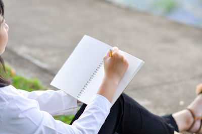 Midsection of woman reading book