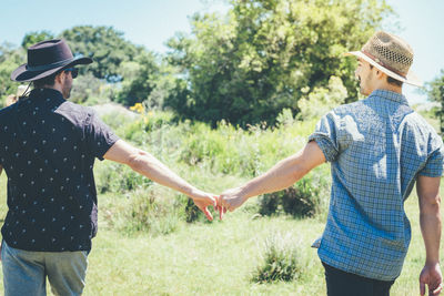 Rear view of couple kissing against trees