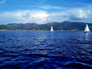 Sailboat sailing on sea against sky