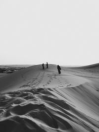 High angle view of women wearing hijab walking in desert