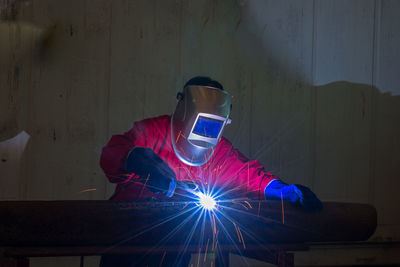 Man welding in dark