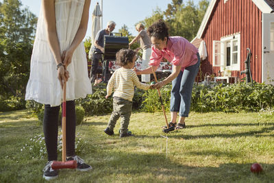 Family playing croquet in garden