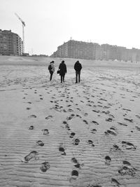 Rear view of people walking on beach