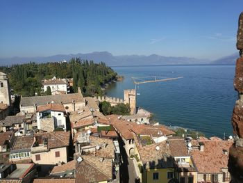 High angle view of town by sea against clear sky