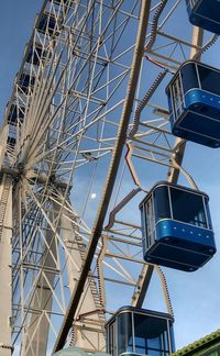 Low angle view of ferris wheel against blue sky